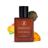 A square-shaped bottle of Zodiaura Zodi Musk perfume EDP spray with a black cap, displayed alongside citrus fruits and a piece of amber, suggesting the fragrance's musk, citrus, and amber accords.